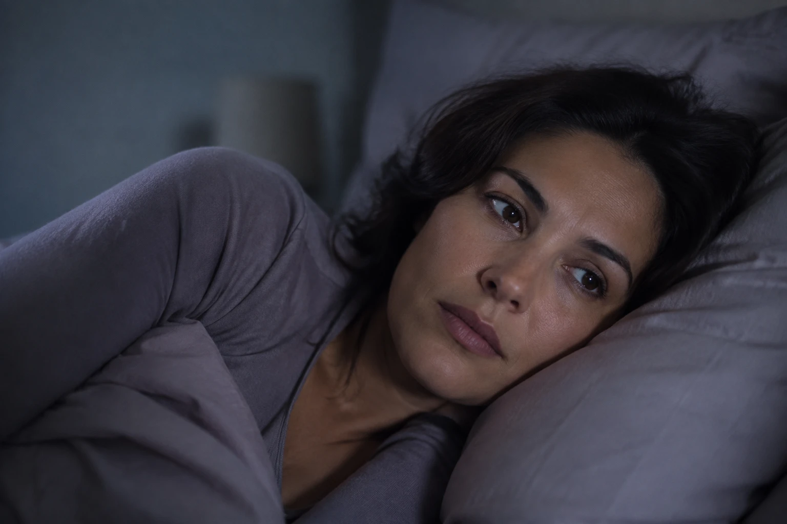 Mujer despierta en la cama durante la noche.